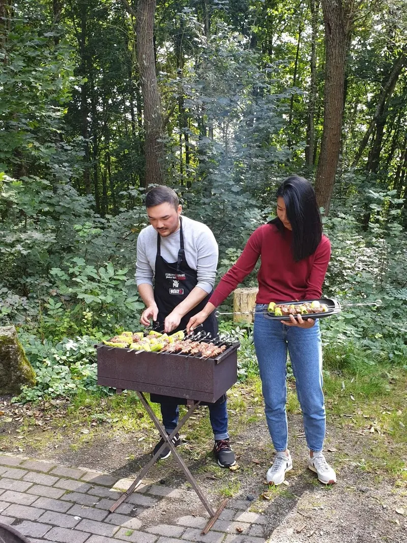 Zwei junge Leute am Grill im Wald